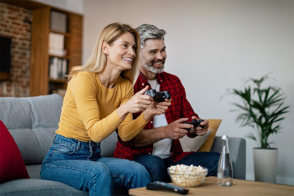 Ein Mann und eine Frau spielen gemeinsam mit einer Spielkonsole